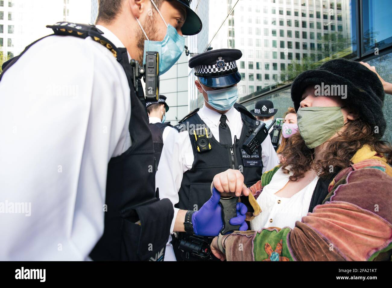 Canary Wharf, London, Großbritannien 22. April 2021 Extinction Rebellion Frauen brechen Fenster bei der HSBC Bank als Teil einer Reihe von Aktionen, aus denen die Geld-Rebellion besteht. Die Umweltgruppe ist wütend über die 80 Milliarden Pfund schweren Investitionen der Bank in fossile Brennstoffe in den letzten 5 Jahren Stockfoto