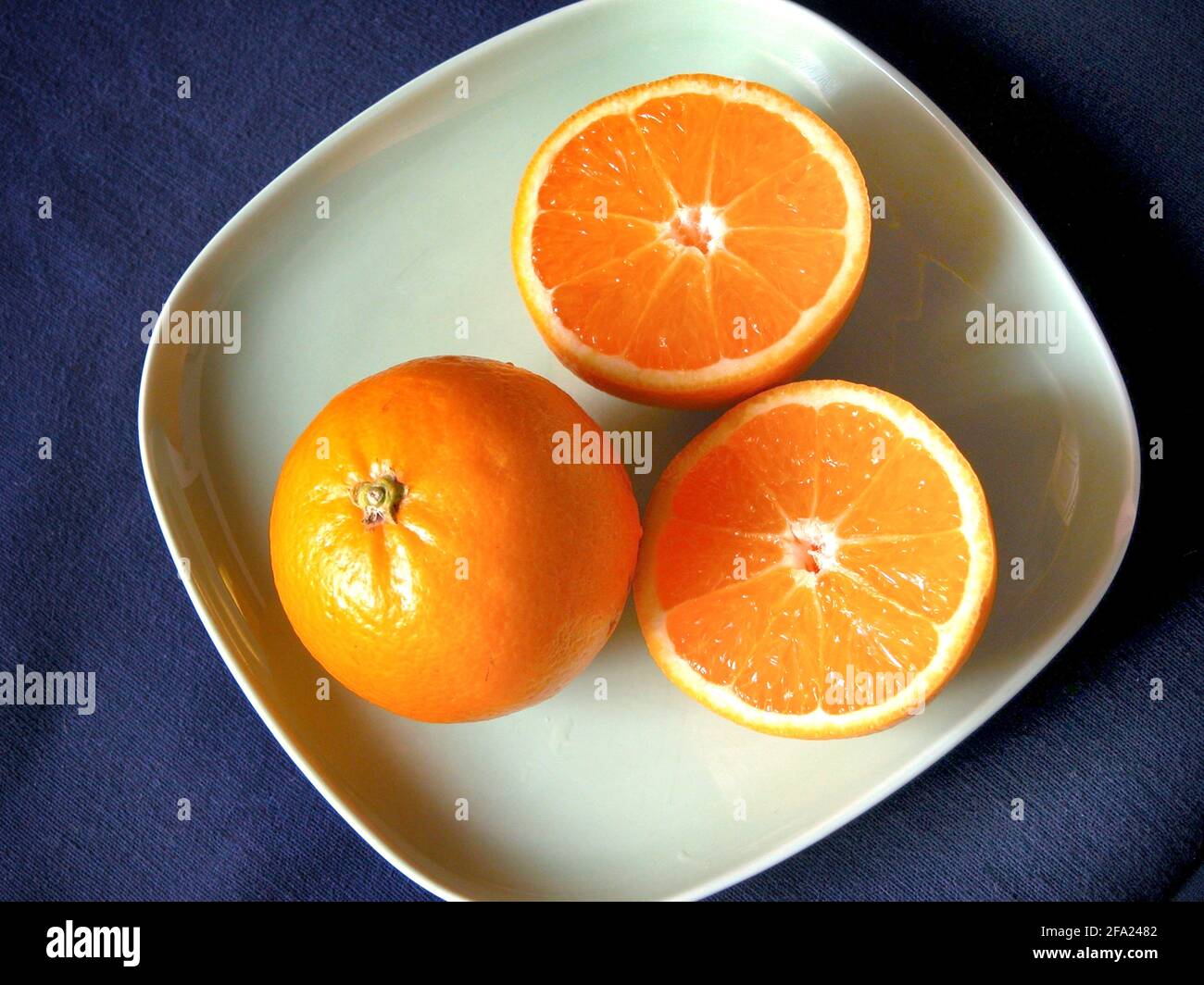 Orange (Citrus sinensis), ganze und halbierte Früchte Stockfoto