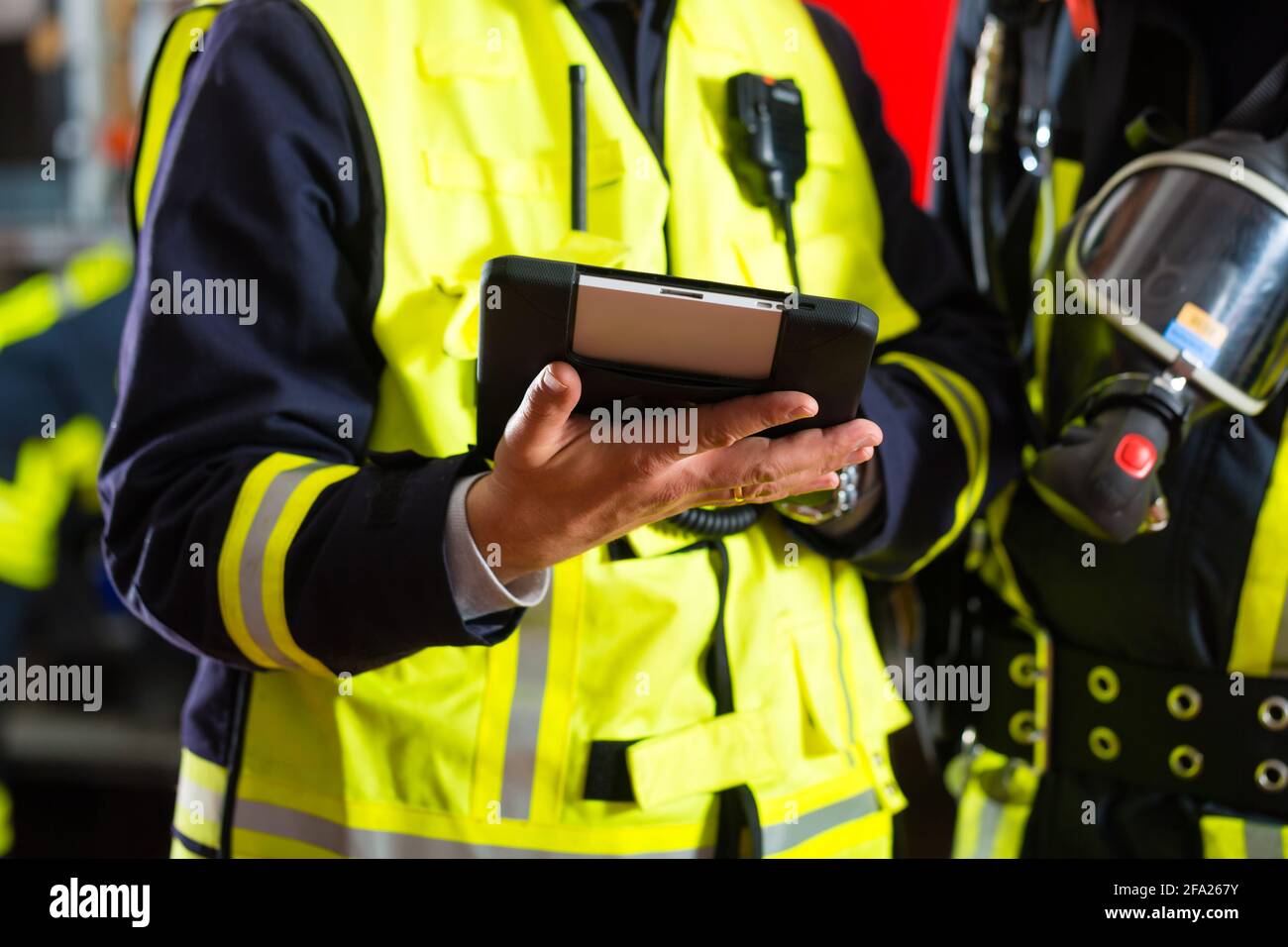 Feuerwehr - Einsatzleiter gibt Anweisungen, benutzte er die Tablet-Computer die Bereitstellung planen Stockfoto