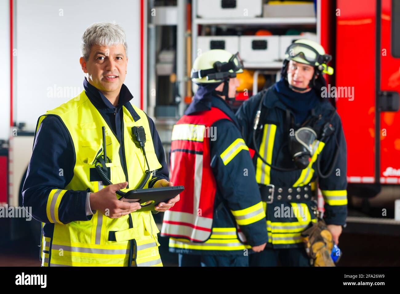 Feuerwehr - Einsatzleiter, verwendet er den Tablet-Computer die Bereitstellung planen und Blick auf den Betrachter Stockfoto