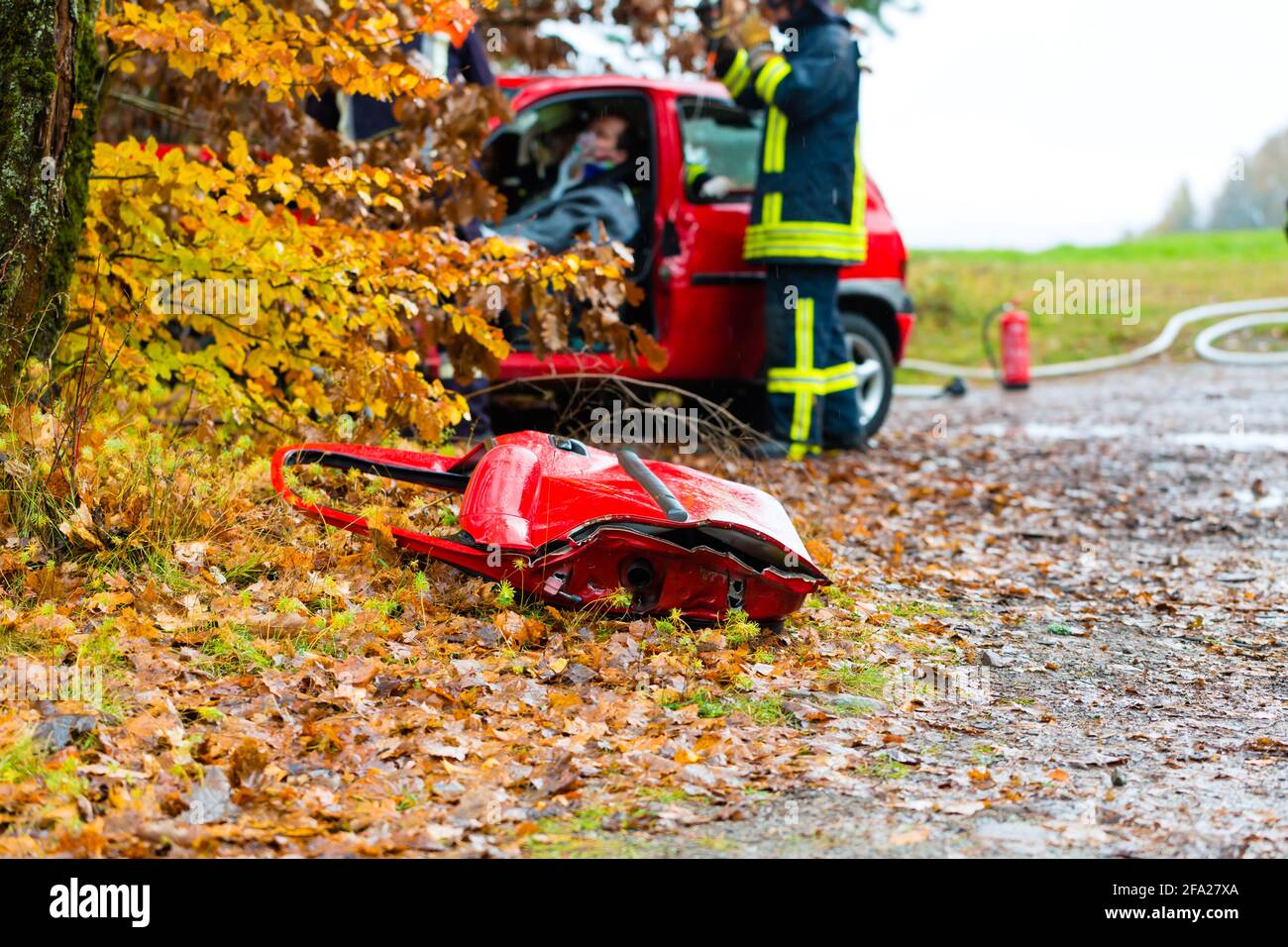 Unfall - Feuerwehr rettet Unfall Opfer eines Autos, einer Autotür auf der rutschigen Fahrbahn liegen Stockfoto