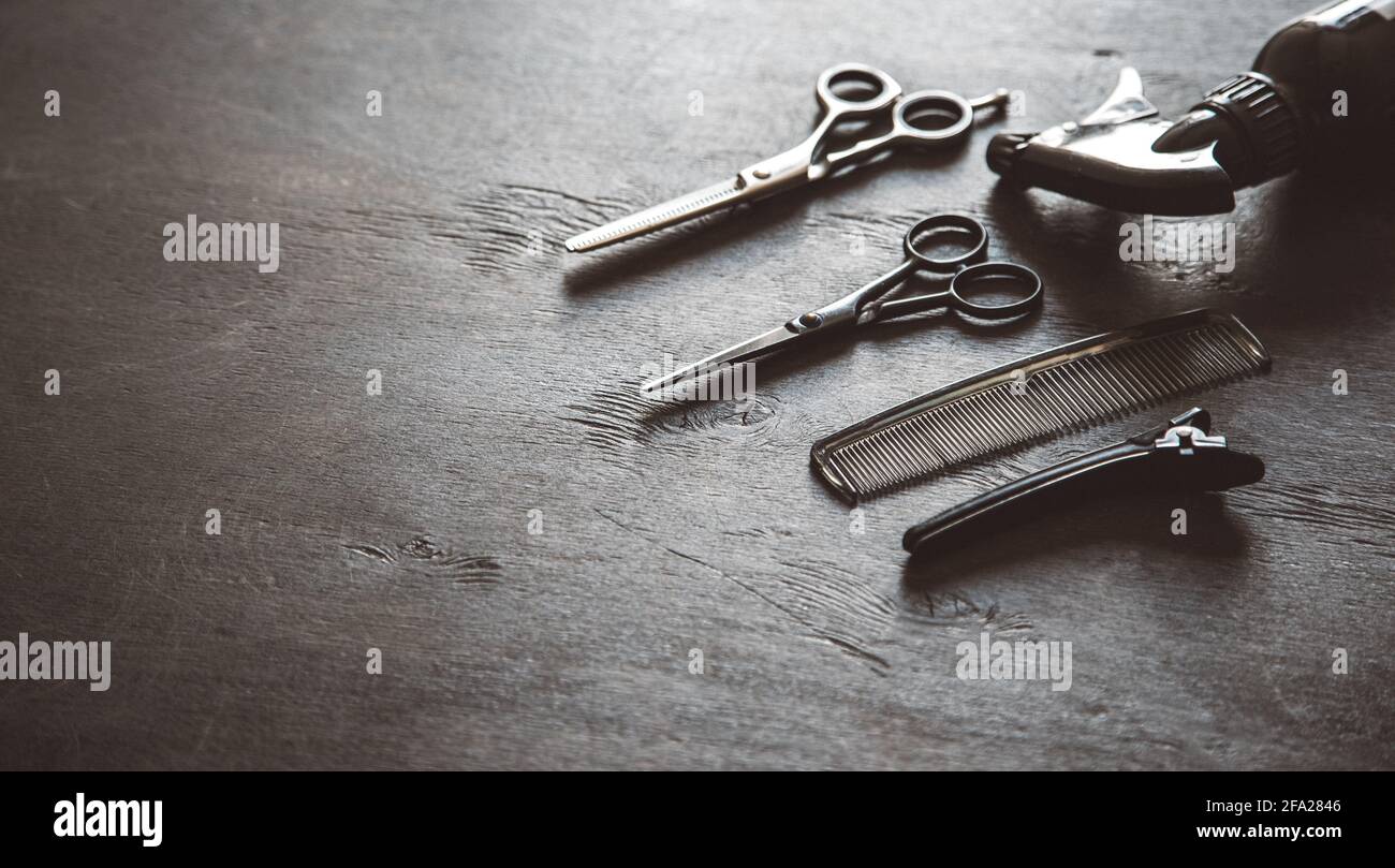 Set von professionellen Friseur-Tools mit Kämmen und Styling auf dunklem Holz Hintergrund Draufsicht Mock up. Stockfoto