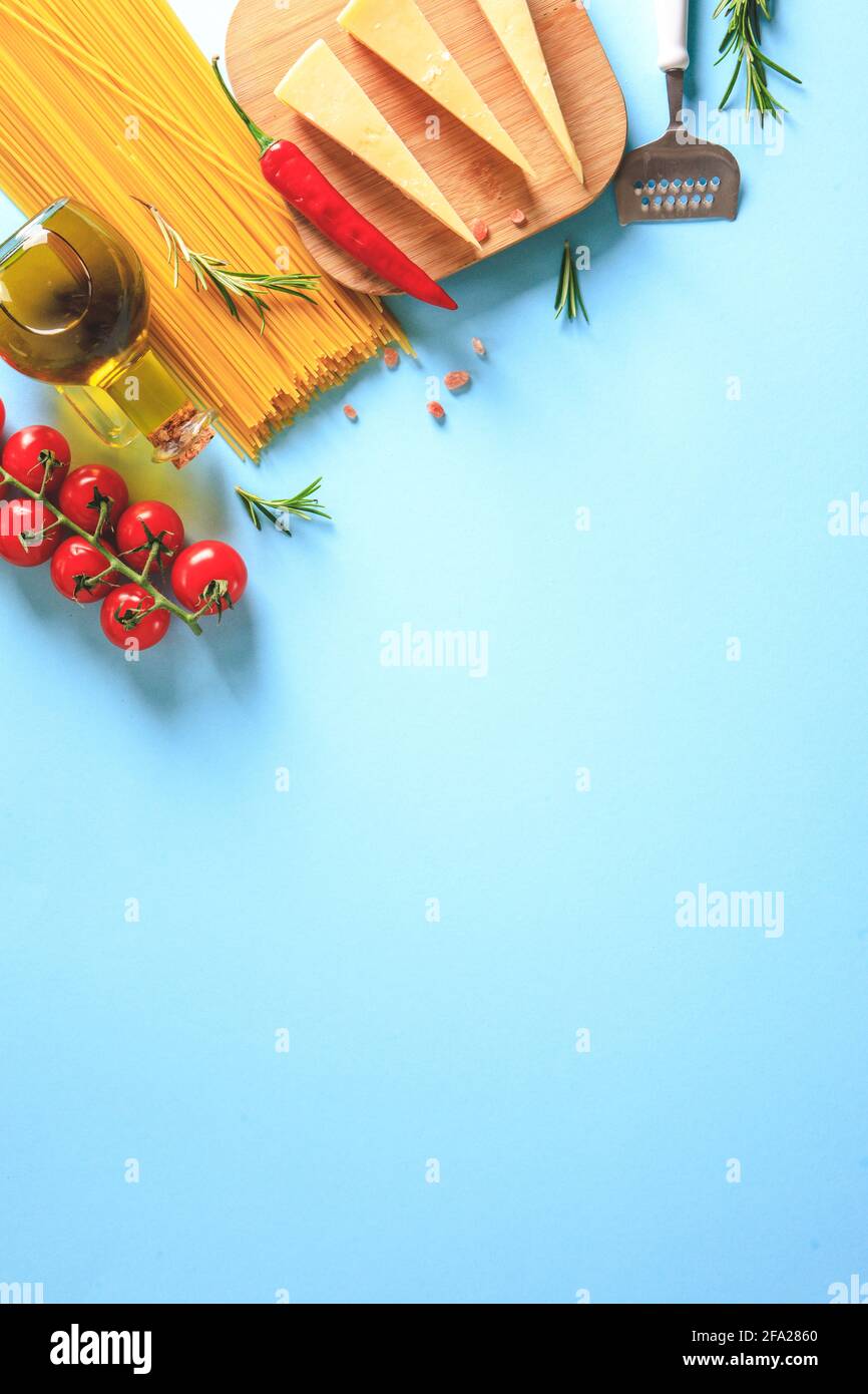 Ungekochte Pasta auf blauem Hintergrund. Draufsicht. Rohe Pasta mit Zutaten zum Kochen. Lebensmittelkonzept. Italienisches Essen. Stockfoto