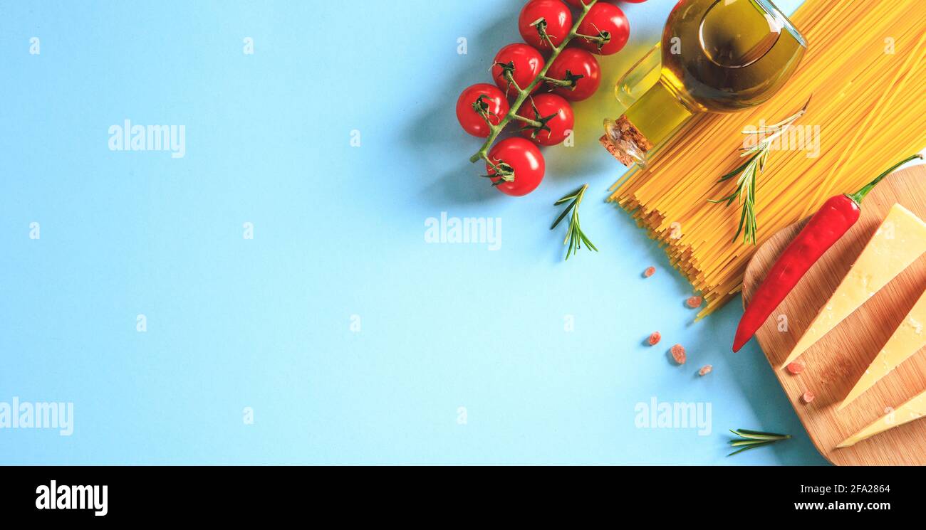Ungekochte Pasta auf blauem Hintergrund. Draufsicht. Rohe Pasta mit Zutaten zum Kochen. Lebensmittelkonzept. Italienisches Essen. Stockfoto