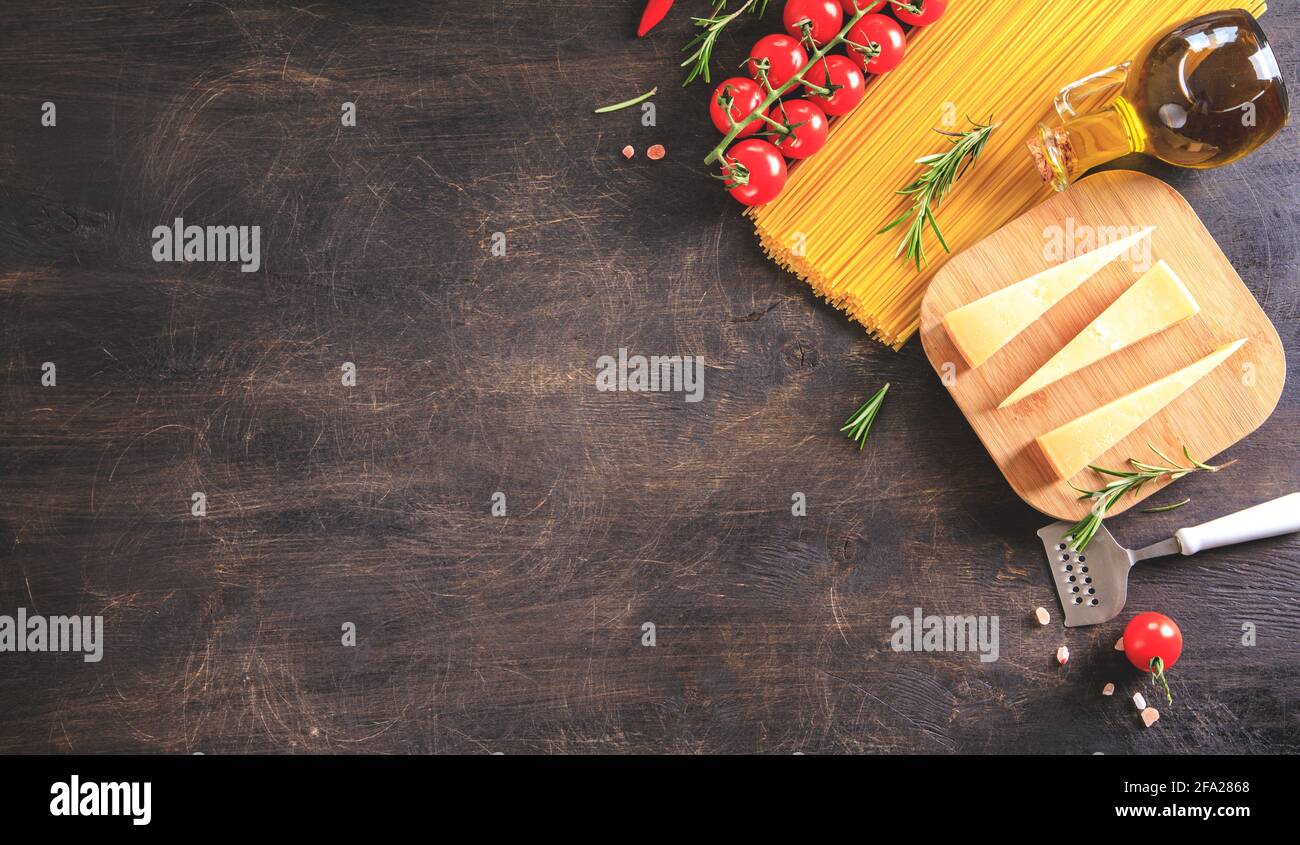Ungekochte Pasta auf Holzhintergrund. Draufsicht. Rohe Pasta mit Zutaten zum Kochen. Lebensmittelkonzept. Italienisches Essen. Stockfoto