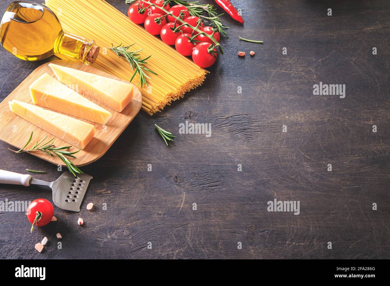 Ungekochte Pasta auf Holzhintergrund. Draufsicht. Rohe Pasta mit Zutaten zum Kochen. Lebensmittelkonzept. Italienisches Essen. Stockfoto