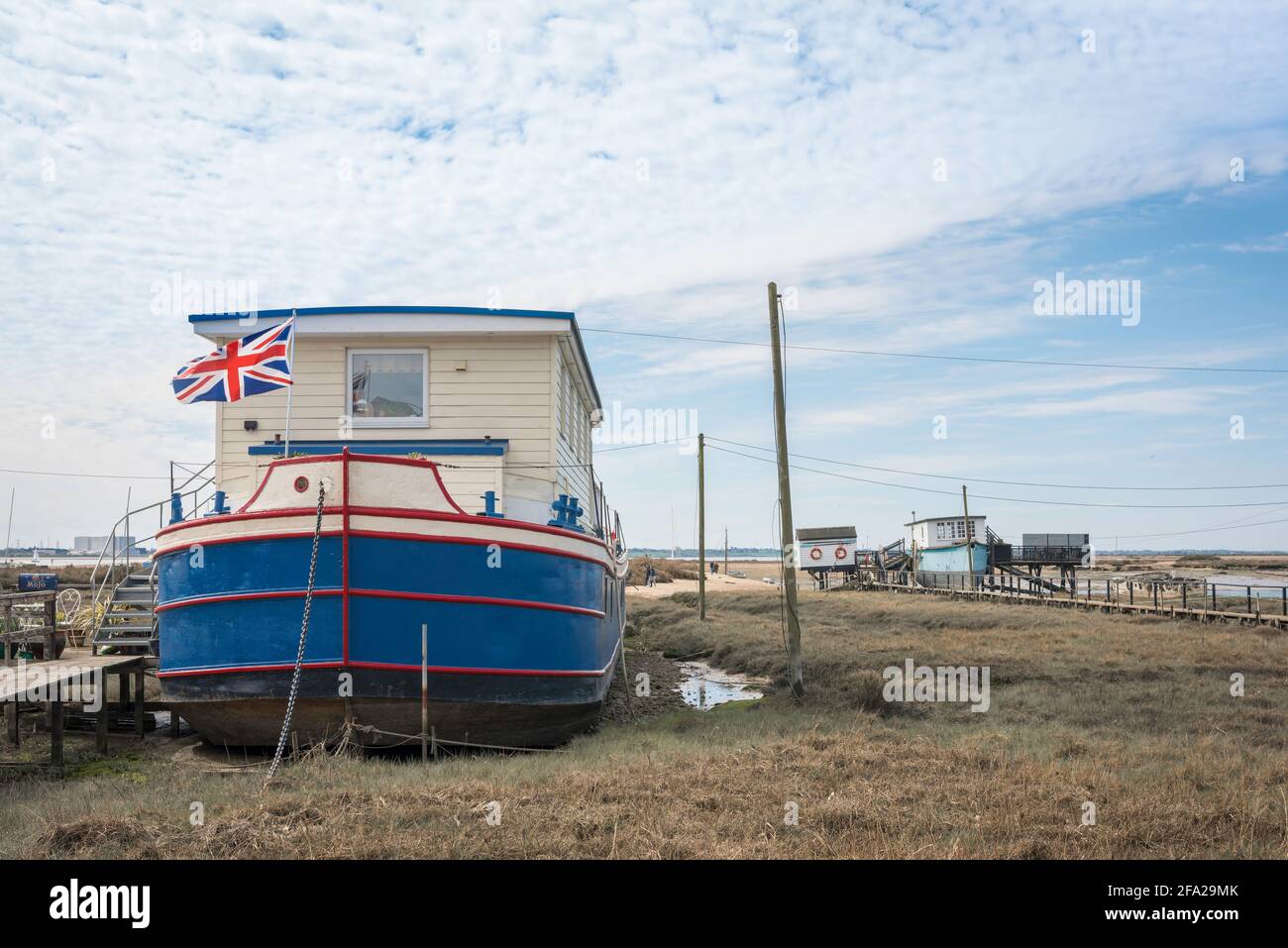 Hausboot UK, Blick auf ein Hausboot, das bei Ebbe an der Schwarzwassermündung des Flusses, Mersea Island, Essex, England, Großbritannien, ruht Stockfoto