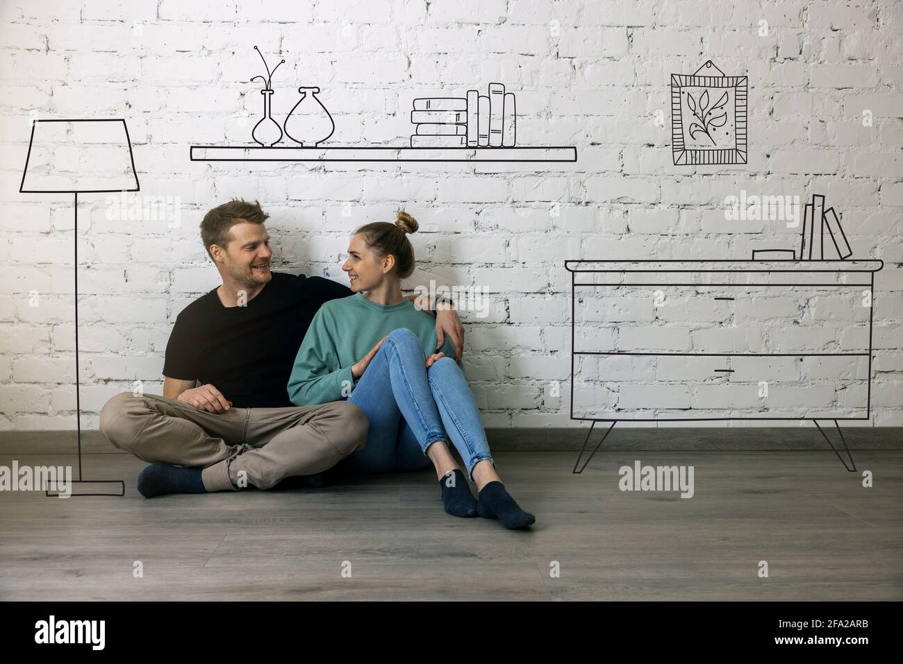 Glückliches Paar sitzt auf dem Boden und Planung neuer Wohneinrichtung. Möbel Skizze Stockfoto