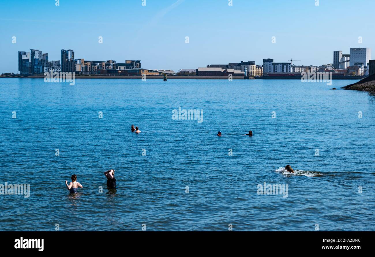 Edinburgh, Schottland, Großbritannien. April 2021. UK Wetter: Frühlingssonne für Wildschwimmer. Wardie Bay in Granton mit Blick auf Platinum Point ist die moderne Hochhauswohnung während der Pandemie zu einem beliebten Ort für Wildschwimmer geworden Stockfoto