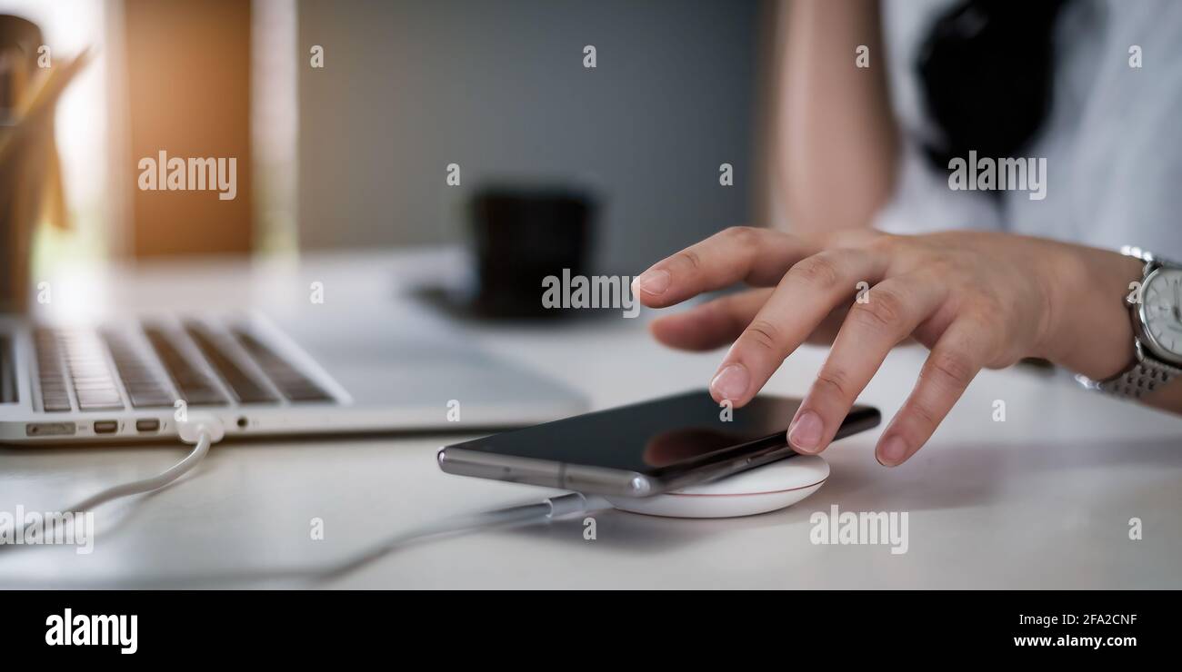 Geschäftsfrau oder Buchhalterin versuchen, das Mobiltelefon abzuholen, während der Kunde anruft. „Work from Home“-Konzept. Stockfoto