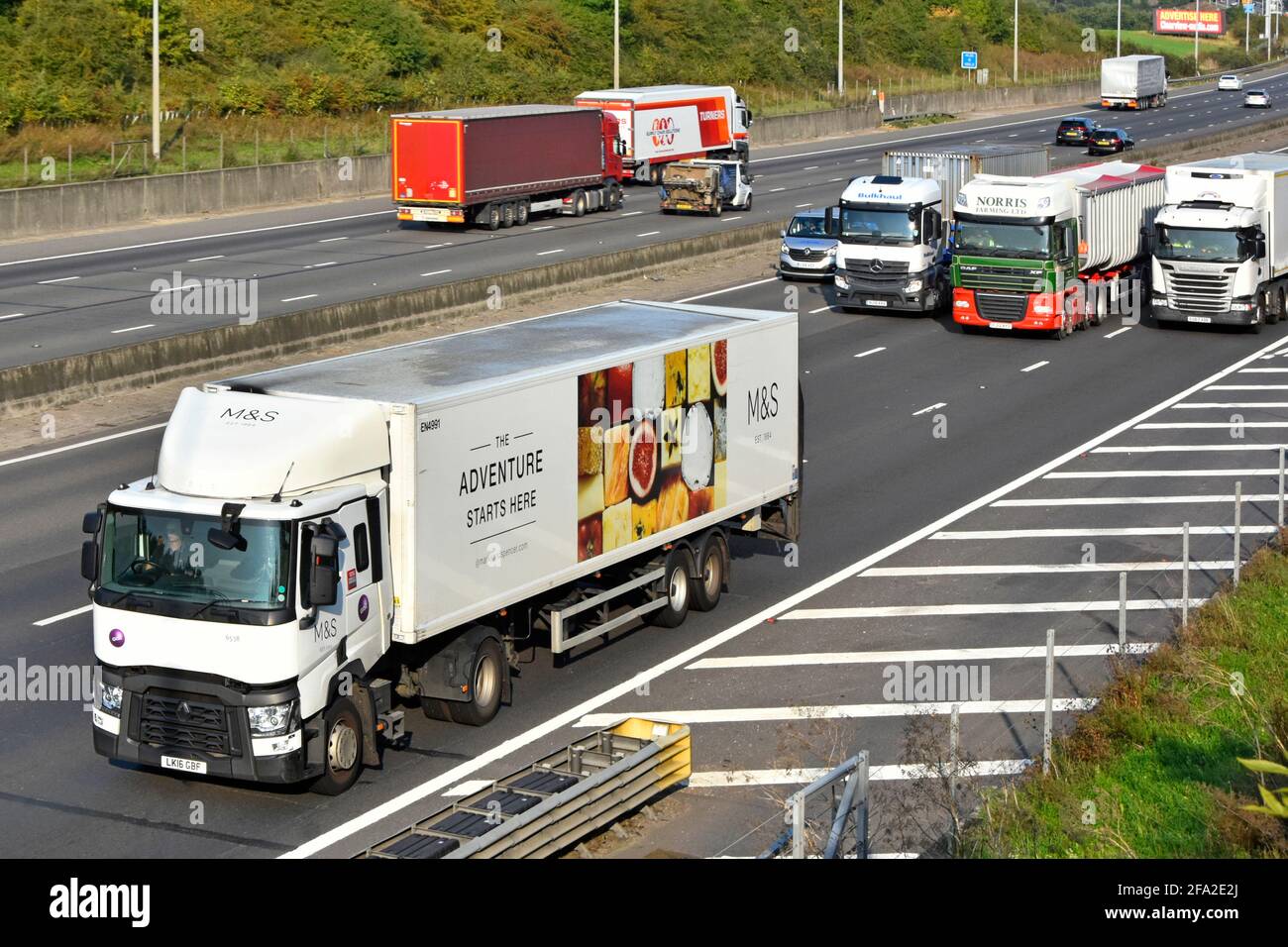 Luftaufnahme lkw-Lastwagen und Güterwagen in Bewegung Verkehr vierspurige zweispurige Autobahn Beton-Crashbarriere hart Schulter England Großbritannien Stockfoto