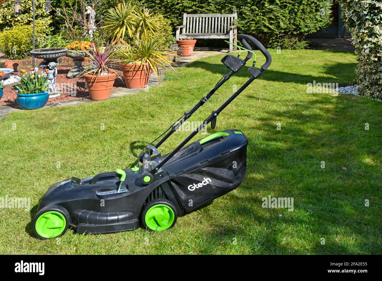 Akku-Rasenmäher GTECH Grasbox nach dem ersten Frühjahrsschnitt Home zurück Garten Rasen mit Lithium-Batterie-Netzteil & Einbrüche für Lagerhaltung England GB Stockfoto