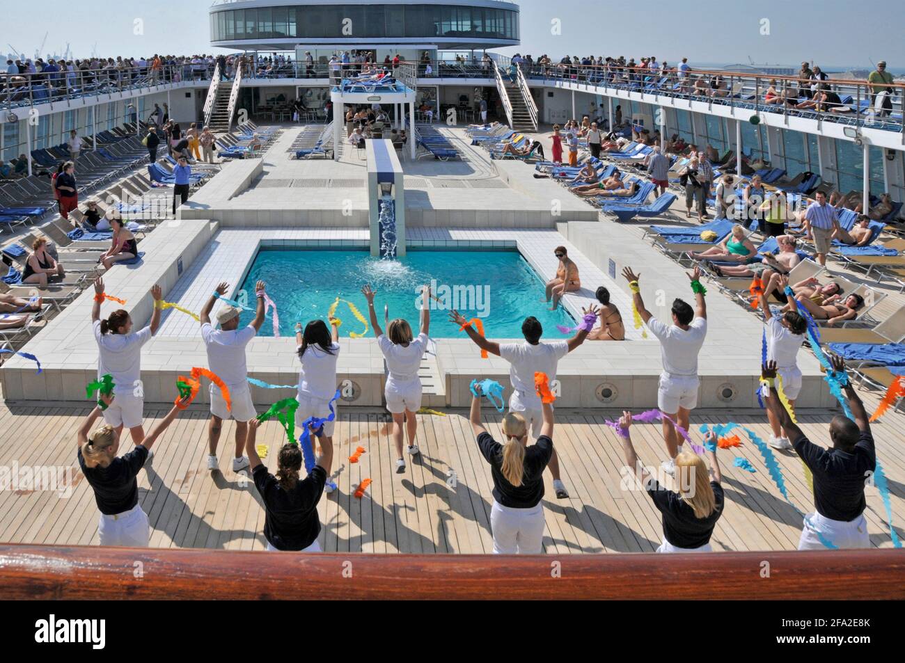 Blick auf das Sonnendeck des Swimmingpools auf dem Kreuzfahrtschiff Costa Classica Schiffe Entertainment-Team Förderung der Bewegung durch die aktive zu halten Abfahrt in Dubai, VAE Stockfoto