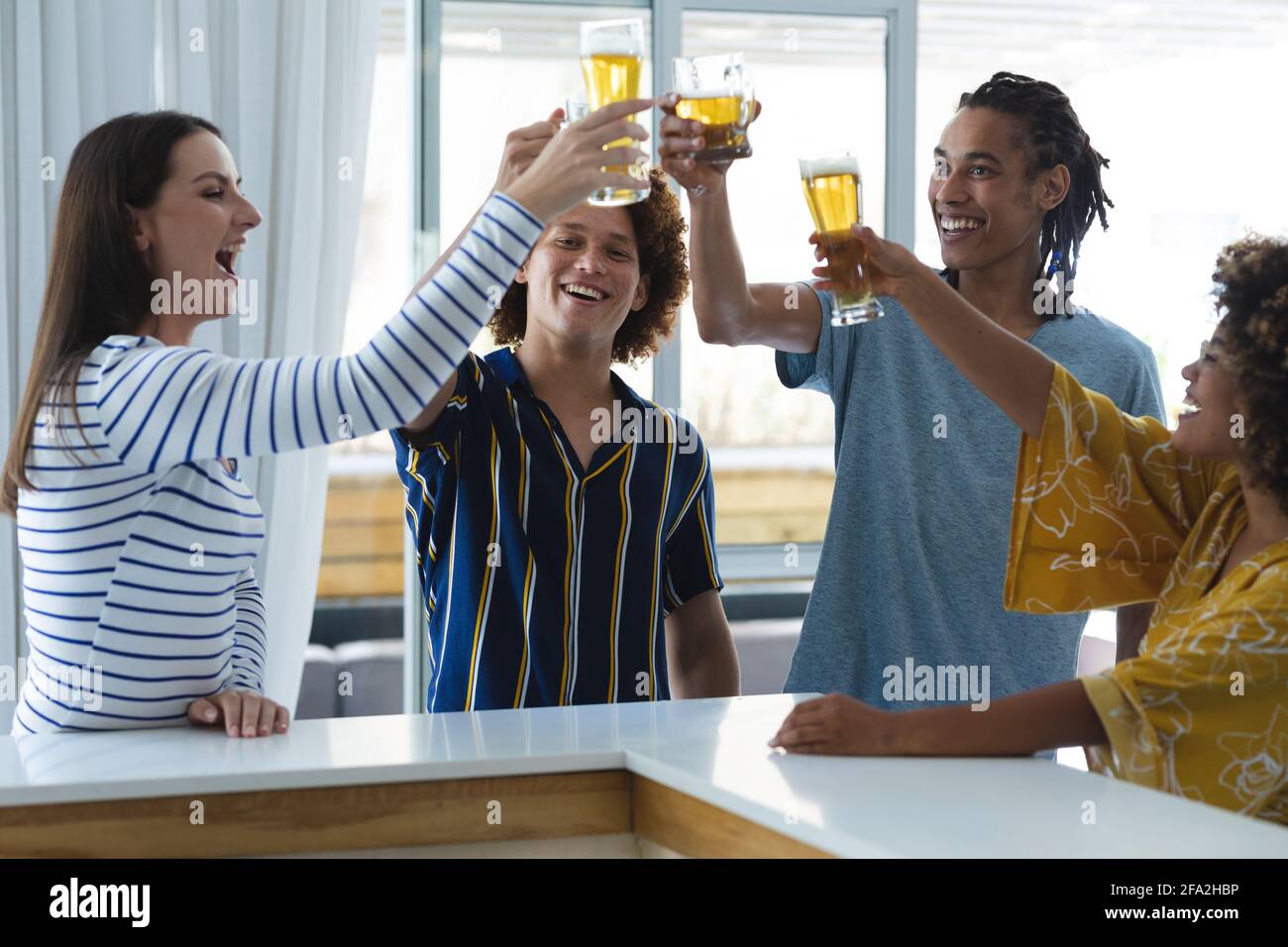 Eine vielfältige Gruppe von männlichen und weiblichen Kollegen, die eine Brille aufziehen Bier an der Bar Stockfoto