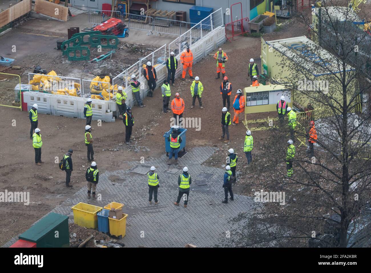 Bauarbeiter treffen sich mit einem physisch distanzierten Team vor Ort Stockfoto
