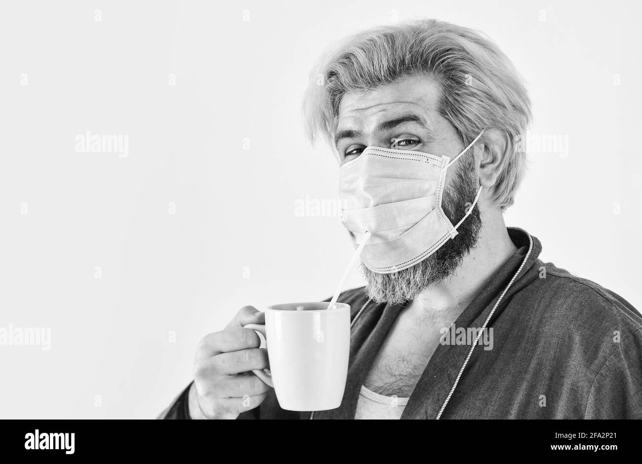 Kerl in Maske trinken Tee Kaffee mit Stroh. Hygiene ist ernst. Mund und Nase mit Maske abdecken und sicherstellen, dass keine Lücken zwischen Gesicht und Maske bestehen. Absolut Stockfoto