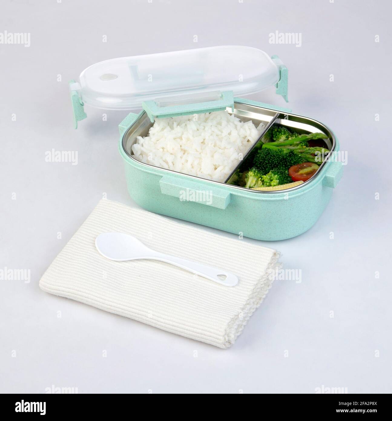 Aufgeklappter Tiffin-Träger oder Lunchbox mit Reis und gebraten Gemüse auf weißem Hintergrund Stockfoto