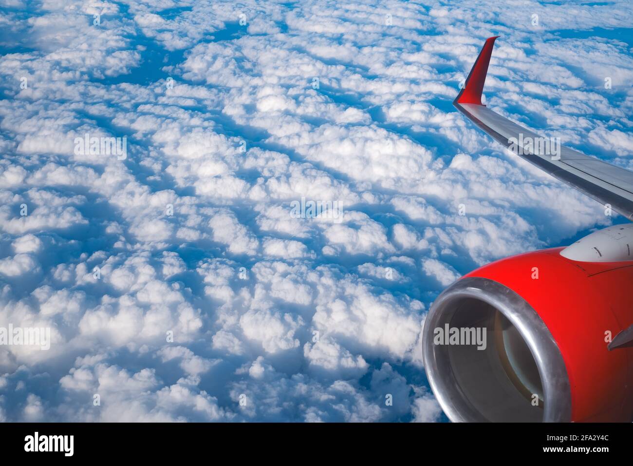 Blick auf Wolken und Flügel aus einem Flugzeugfenster Stockfoto