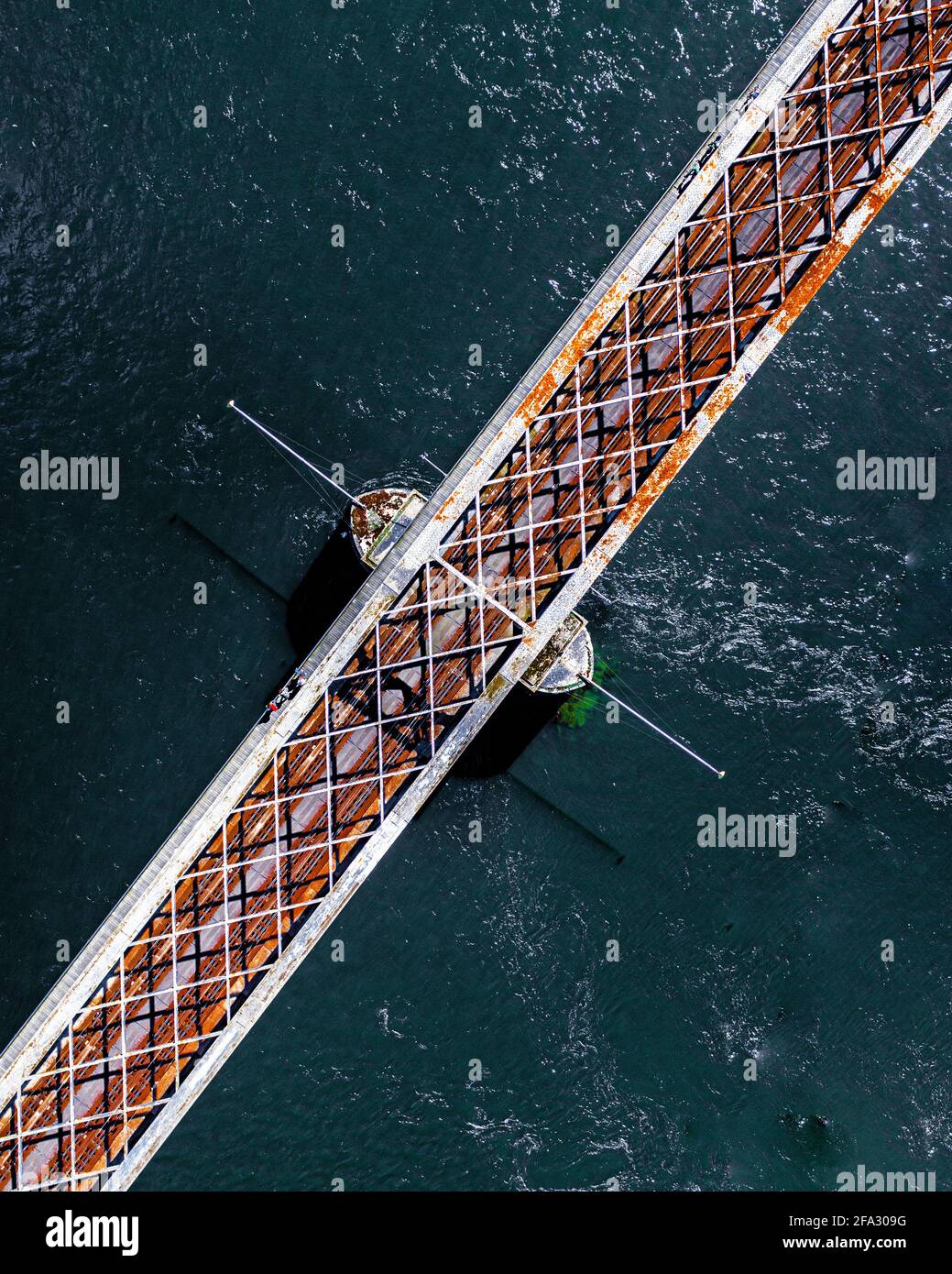 SIEGEN, DEUTSCHLAND - 09. Apr 2021: Brücke umgeben von einer Dronen-Fotografie von oben auf dem Wasser Stockfoto