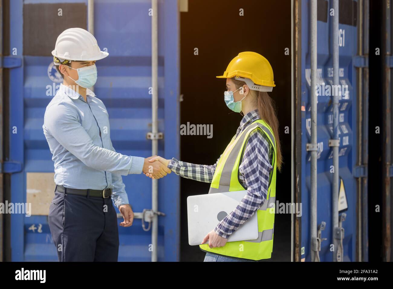 Industriearbeiterin, Frau und Ingenieur, Kontrollarbeiterin, die vor dem Hotel einchecken Tür des Frachtcontainers am Containerfrachthafen Stockfoto