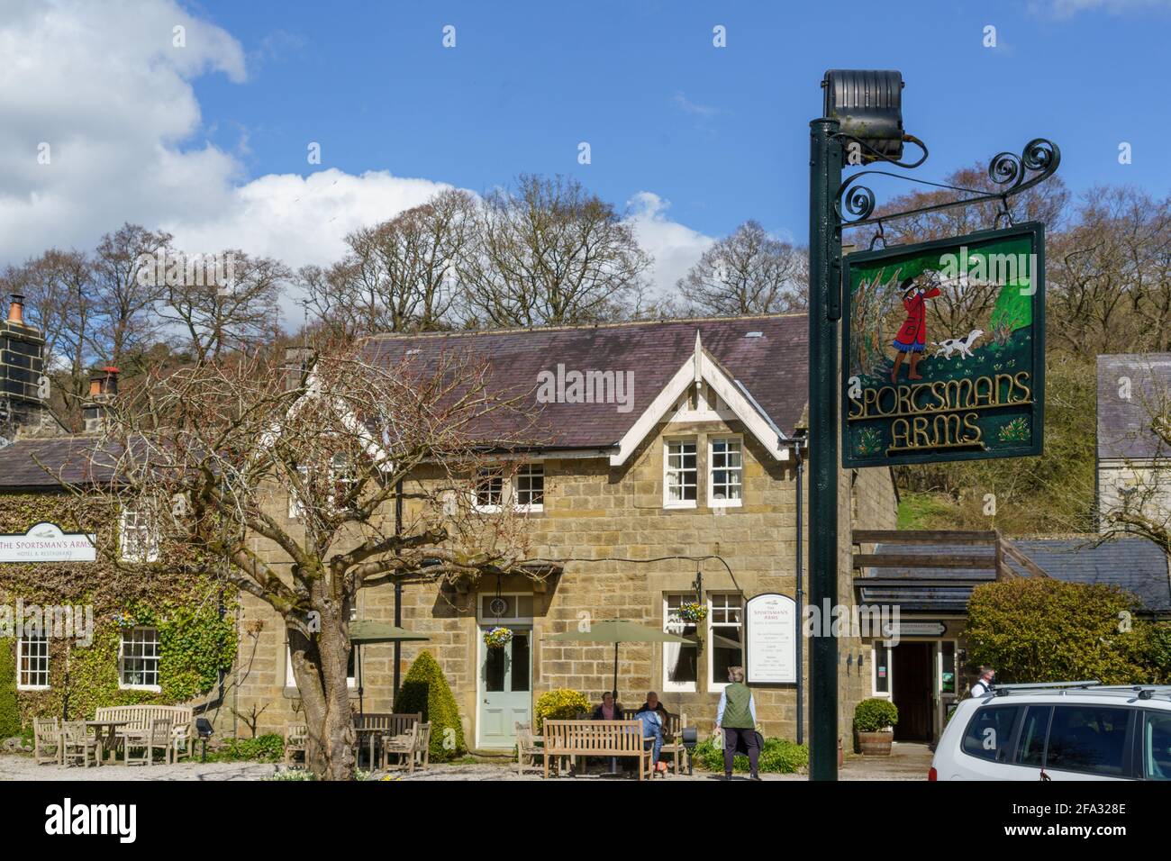 An einem hellen Frühlingsnachmittag saßen die Besucher vor dem Sportsman's Arms Public House, Nidderdale, North Yorkshire, England, Großbritannien. Stockfoto