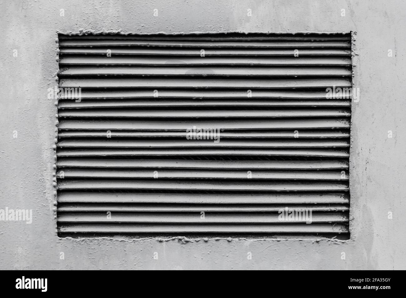 Das Lüftungsgitter ist in der grauen Wand des Trafokastenhintergrunds montiert. Stockfoto