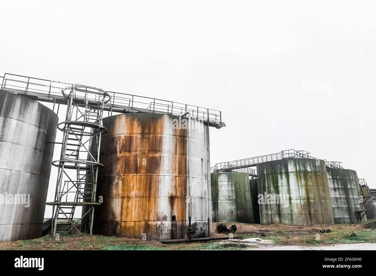 Alte Kraftstofftanks mit Ölflecken in einem verlassenen Industriewerk. Stockfoto