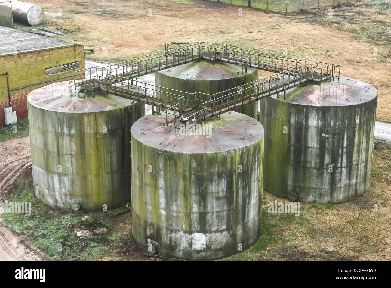 Alte Heizöl-Tanks mit Schmierölflecken in einem verlassenen Industriewerk. Stockfoto