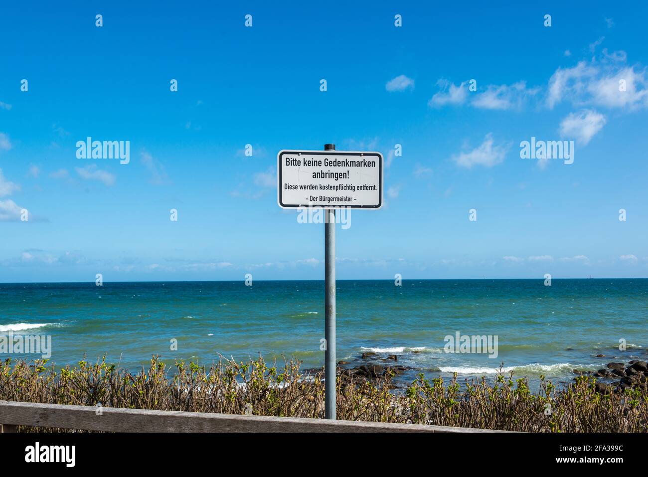 Wanderweg an der Küste der Kieler Förde hier am Leuchtturm von Bülk an der Kieler Außenförde im Frühjahr. Schild 'Bitte keine Gedenkmarken anbringen!' Stockfoto