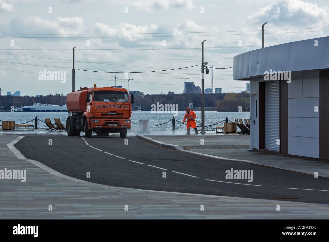Moskau, Russland - 22 2021. April: Stadtarbeiter reinigen den Damm mit Hochdruckwasserausrüstung. Stockfoto