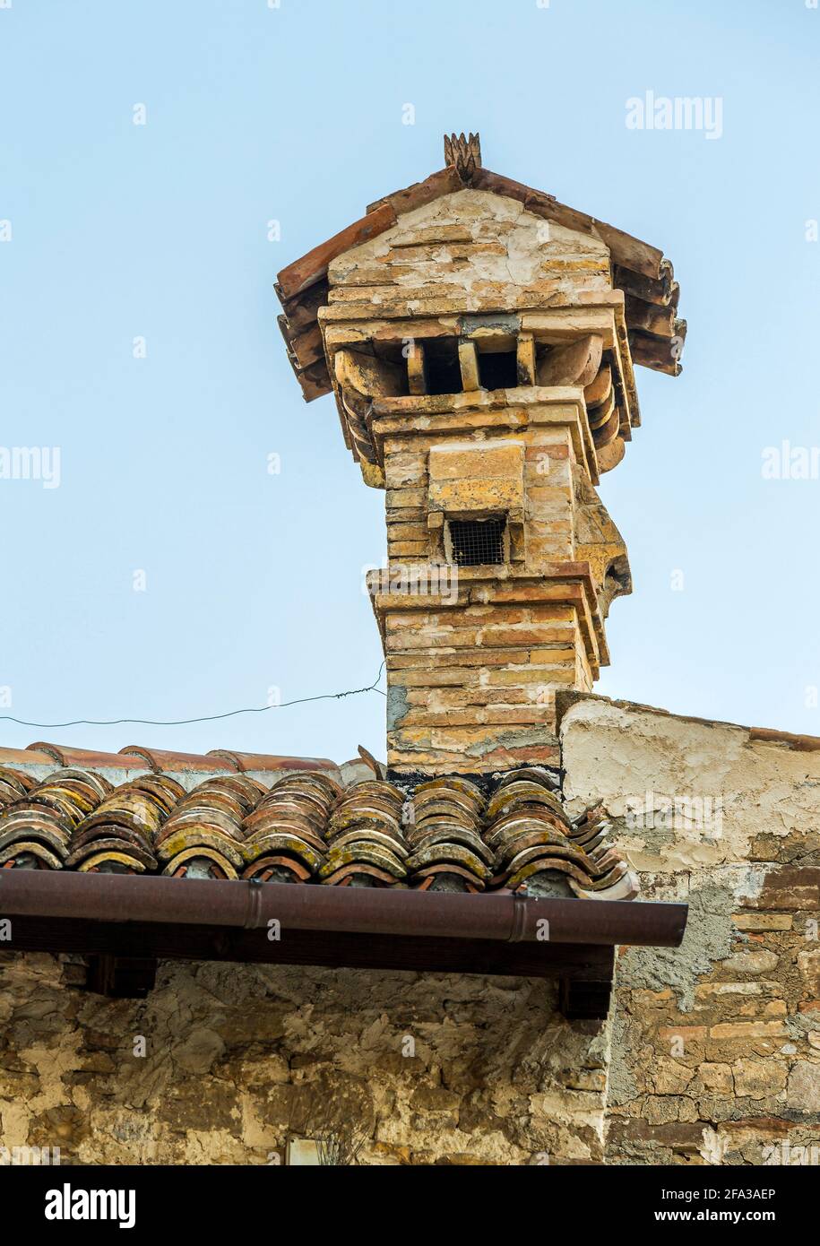 Antiker Kamin aus Ziegeln und Fliesen auf dem Dach eines Steinhauses. Abruzzen, Italien, Europa Stockfoto