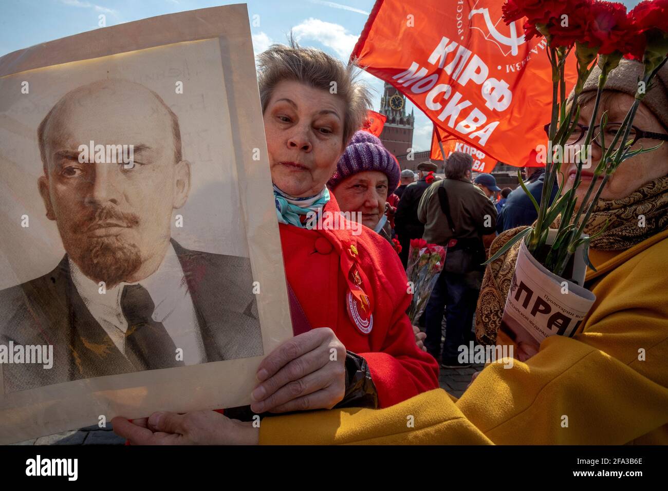 Moskau, Russland. 22. April 2021 EINE Frau hält ein Porträt des sowjetischen Führers Wladimir Lenin, während russische kommunistische Anhänger auf dem Roten Platz im Zentrum Moskaus, Russland, das Mausoleum des sowjetischen Gründers Wladimir Lenin besuchen, um den 151. Jahrestag seiner Geburt zu begehen Stockfoto