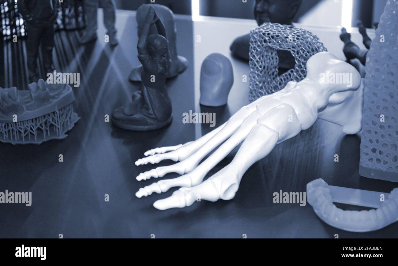 Weißer Prototyp des menschlichen Fußskeletts auf 3d-Drucker auf dunkler Oberfläche gedruckt. Stockfoto
