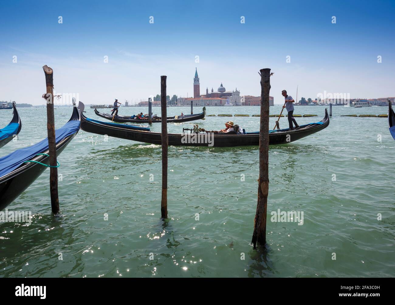 Venedig, Provinz Venedig, Region Venetien, Italien. Gondeln im Bacino di San Marco. San Giorgio Maggiore dahinter. Venedig und seine Lagune sind ein UNESCO W Stockfoto