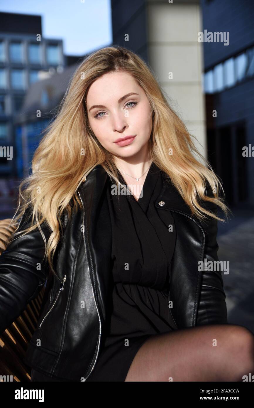 Junge Frau in Breslau. Studentin mit blonden Haaren, in schwarzer Jacke. Stockfoto