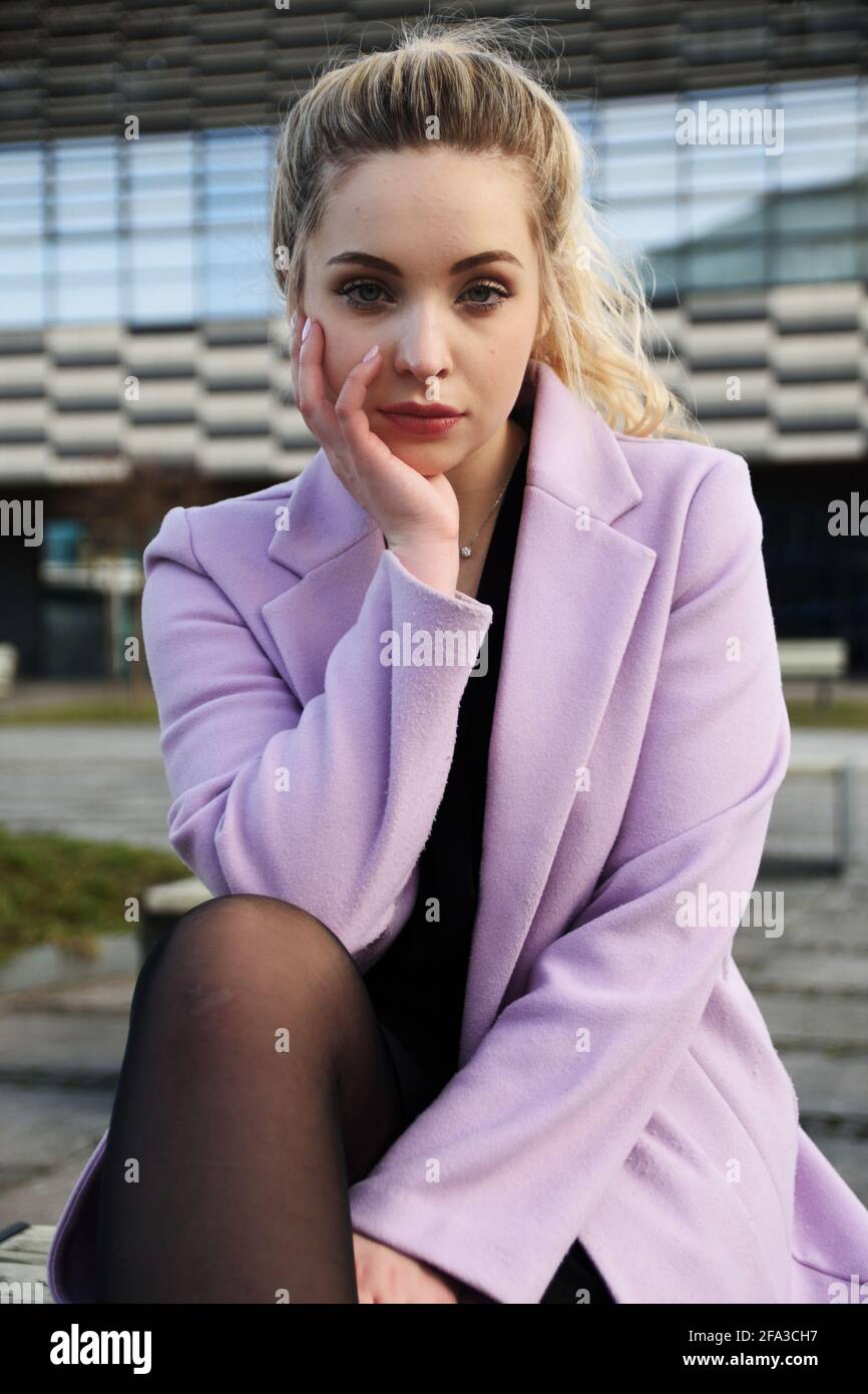 Junge Frau in Breslau. Studentin mit blonden Haaren, mit violettem Mantel. Stockfoto
