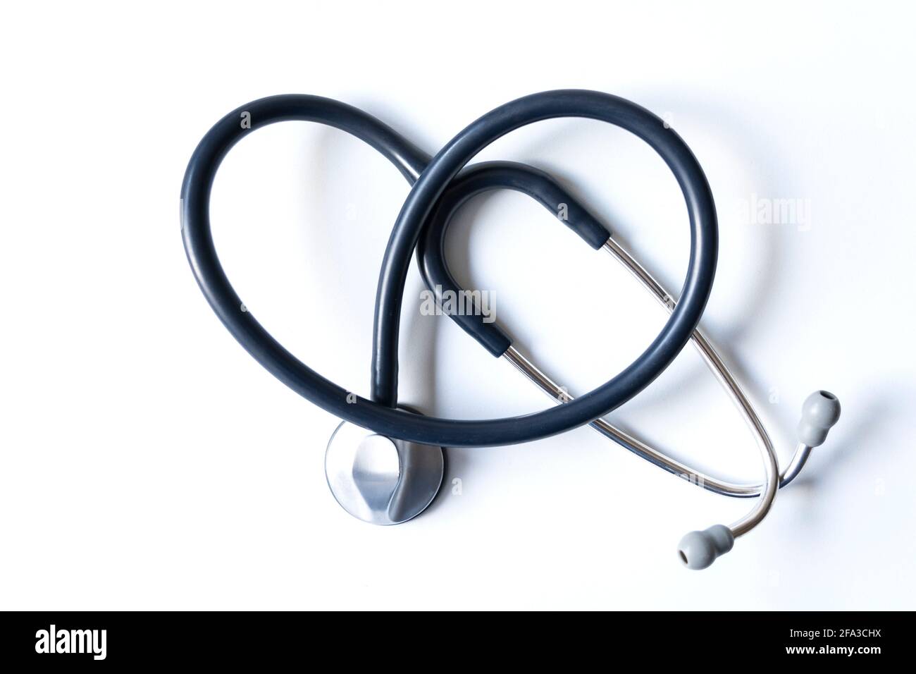 Stethoskop bildet ein Herz auf weißem Hintergrund. Stockfoto