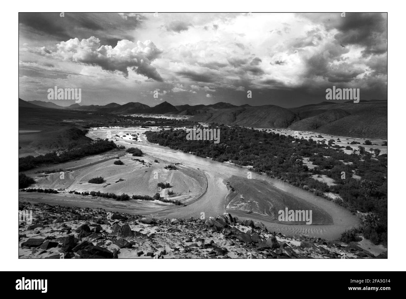 Unabhängiger Weihnachtsschmuck...... Integrierte ländliche Entwicklung und Naturschutz (IRDNC) in Namibia die trockene Wüstenlandschaft Namibias wartet auf die ersten Regenfälle der Saison. Ein klarer, bakeing blauer Himmel wird langsam in ein tiefes Dunkelgrau gekocht, während die Wolken sich einrollen. Der Regen stürmt und sobald knochentrockene Flüsse zum Leben erwacht. Der Horaseb River am Tag nach den ersten Regenfällen der Saison. Foto von David Sandison November 2004 Stockfoto