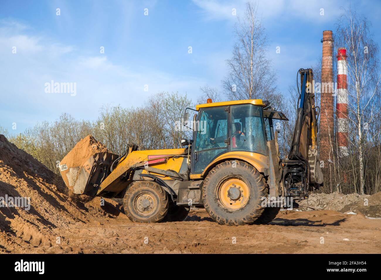 Traktor mit Sand im Eimer an einem klaren Tag Und blauer Himmel im Rücken in geringer Tiefe Angezeigt Stockfoto