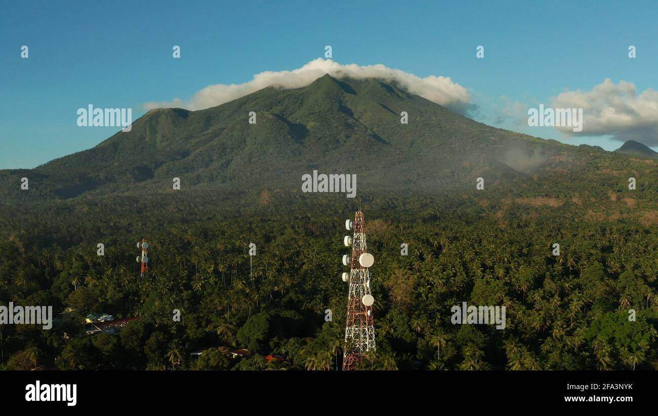Telecommunication Tower, Kommunikation Antenne gegen Berge und Regenwald, Luftbild. Repeater auf einem Turm. Camiguin, Philippinen Stockfoto