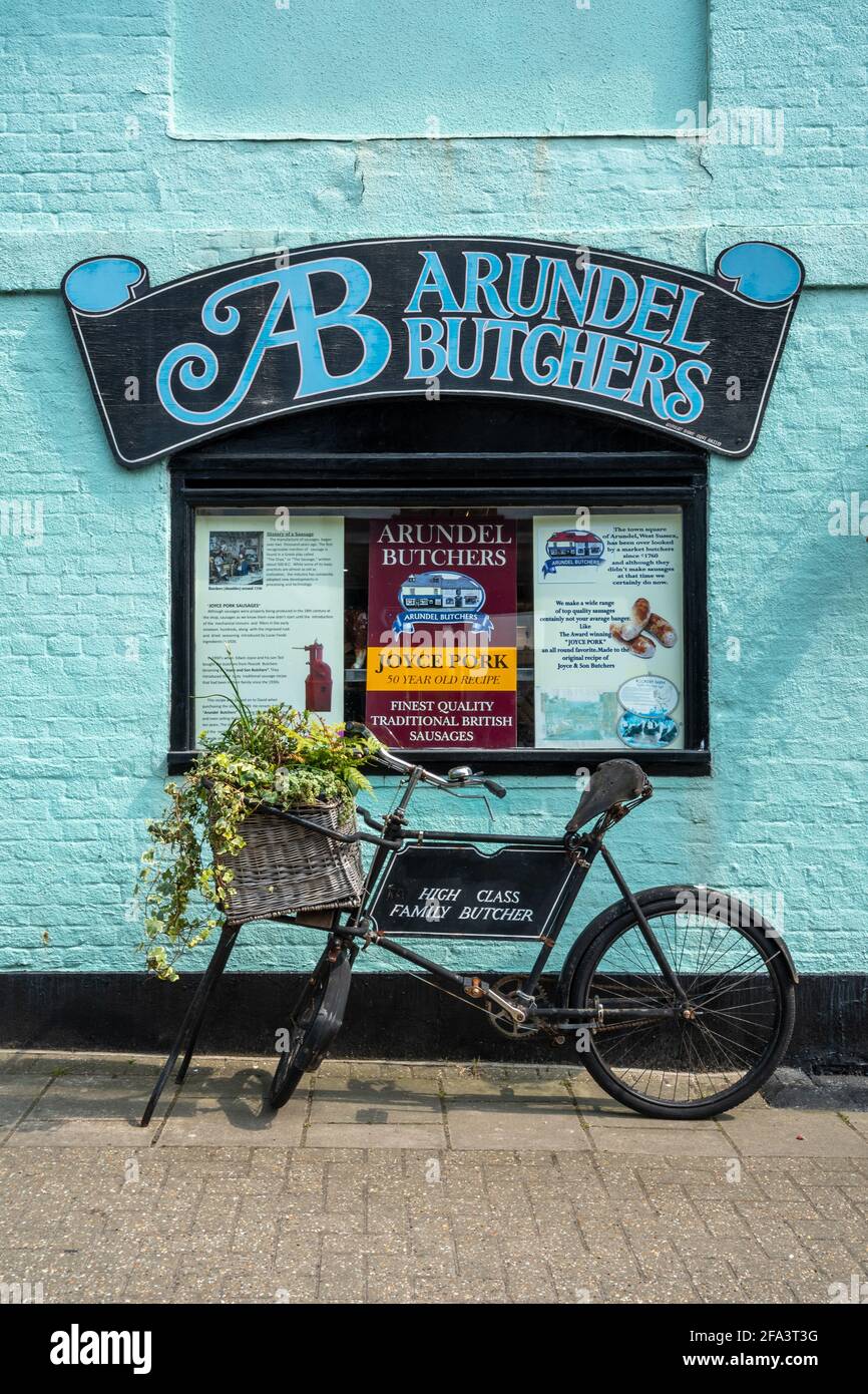 Altmodische Metzgereien Fahrrad und Zeichen auf bunte Wand im Arundel Metzgerladen, Arundel Stadtzentrum, West Sussex, Großbritannien Stockfoto