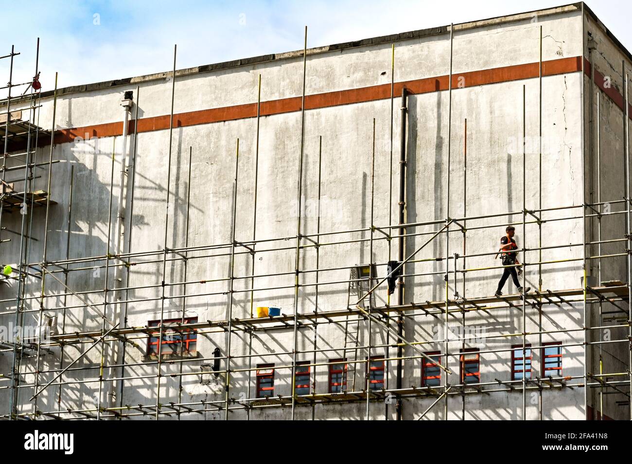 Pontypridd, Wales - 2021. April: Arbeiter, die über eine Plattform auf Gerüsten um das alte County Cinema im Stadtzentrum von Pontypridd gehen. Stockfoto