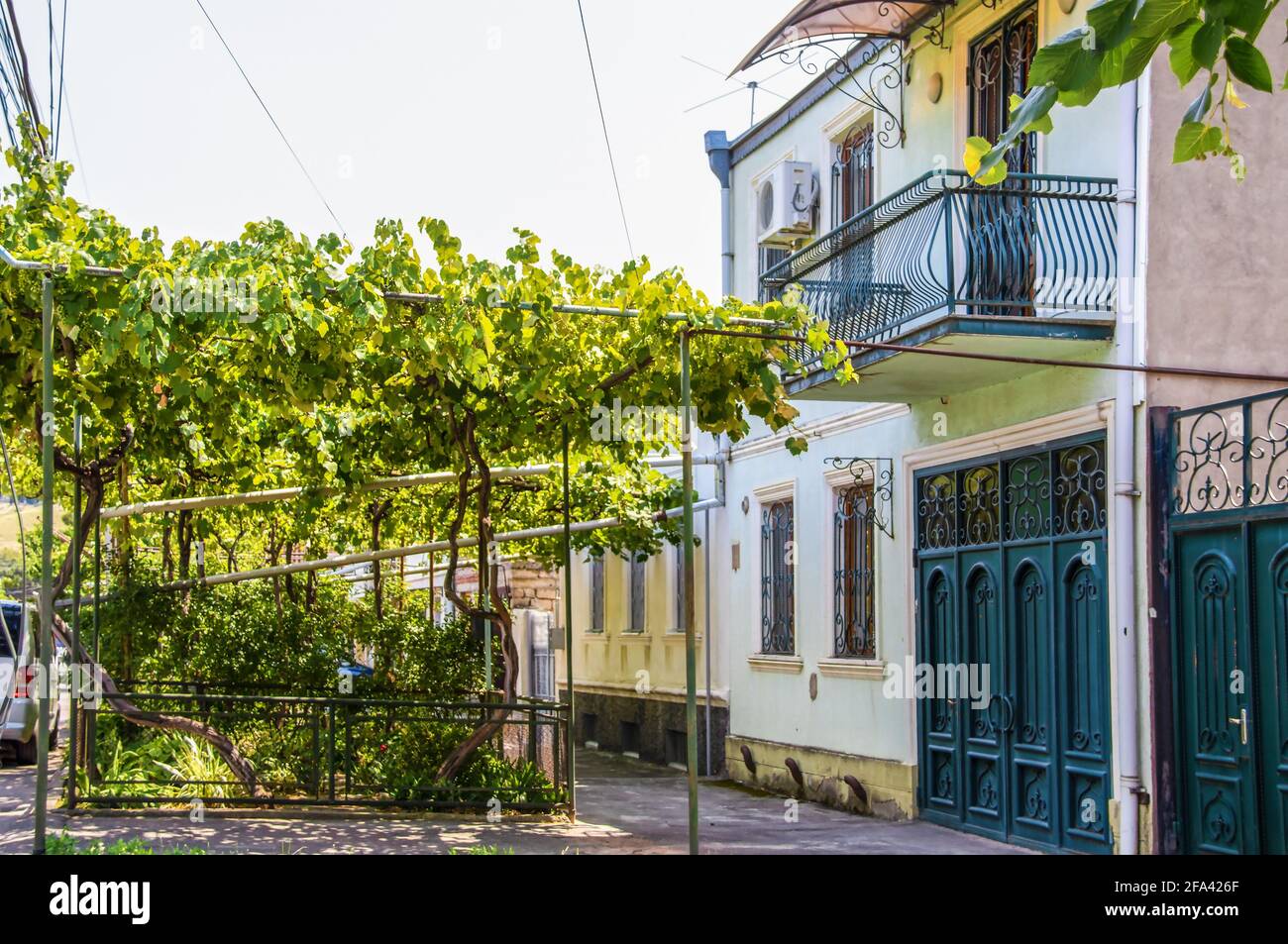 Reihenhaus in Gori, Georgien, wo Stalin mit Gasleitungen aus der Sowjetzeit geboren wurde, die für den Anbau von Trauben im Vorgarten verwendet wurden. Stockfoto