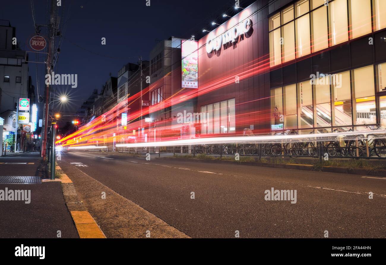Tokio, Japan - Oktober 20 2020: Langzeitbelichtung von Lichtspuren, die von vorbeifahrenden Autos auf der Straße im Westen Tokios gemacht wurden Stockfoto