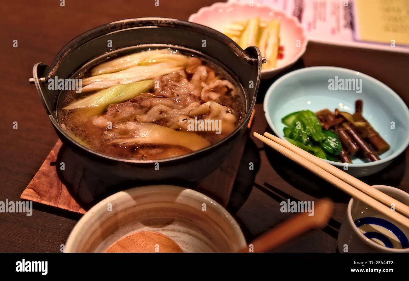 Konzentrieren Sie sich auf eine Schüssel mit Imoni, einem traditionellen Eintopf aus Rindfleisch und Kartoffeln aus der japanischen Yamagata-Region, zusammen mit einigen Beilagen Stockfoto