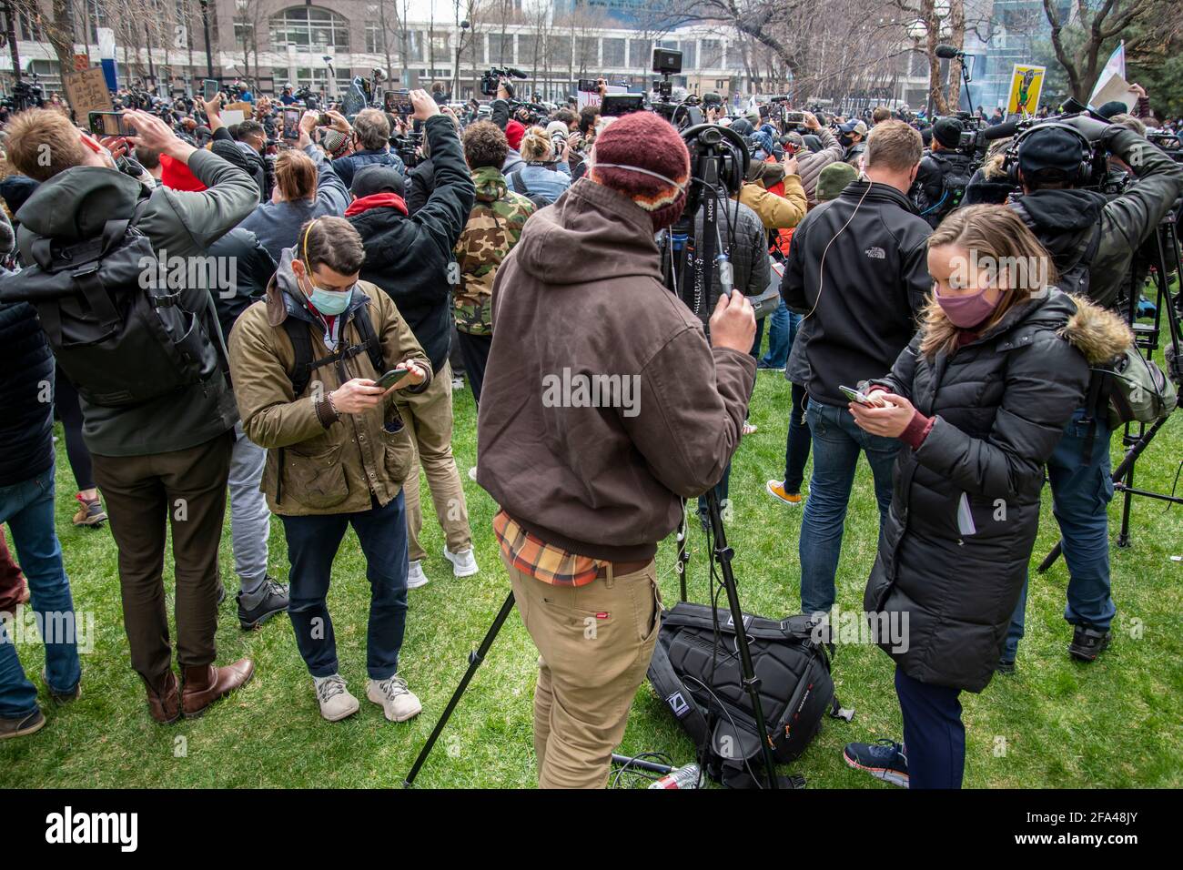 Minneapolis, Minnesota. Die Menschen beobachten ihre Telefone, heben ihre Fäuste und machen Fotos, während das Schuldspruch in der Tria von Derek Chauvin vorgelesen wird Stockfoto