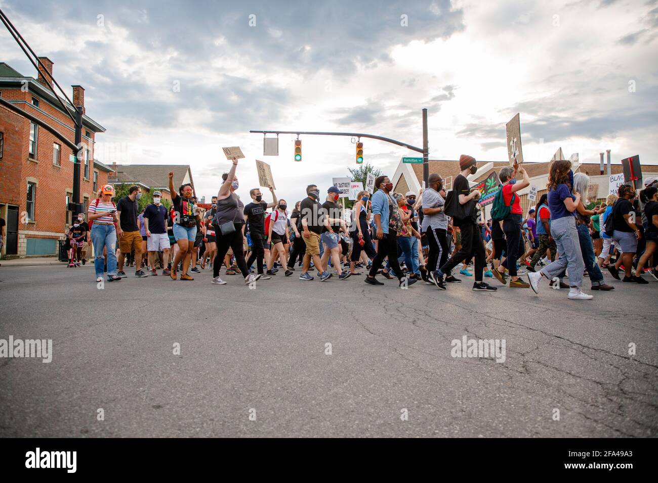 Eine große Gruppe von Protestierenden marschiert friedlich die Straße entlang Schilder Stockfoto