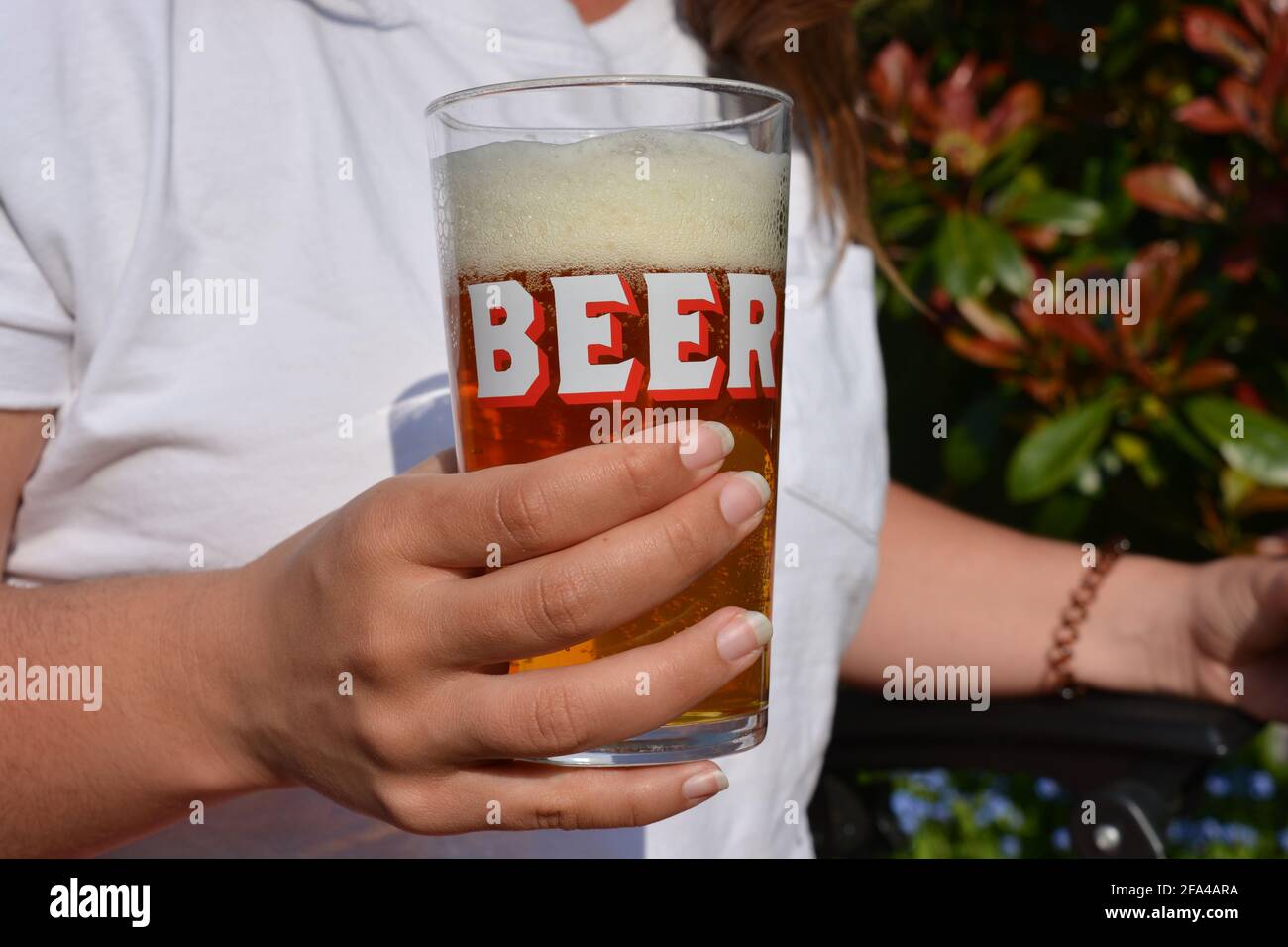 Bierglas in der Hand der Frau Stockfoto