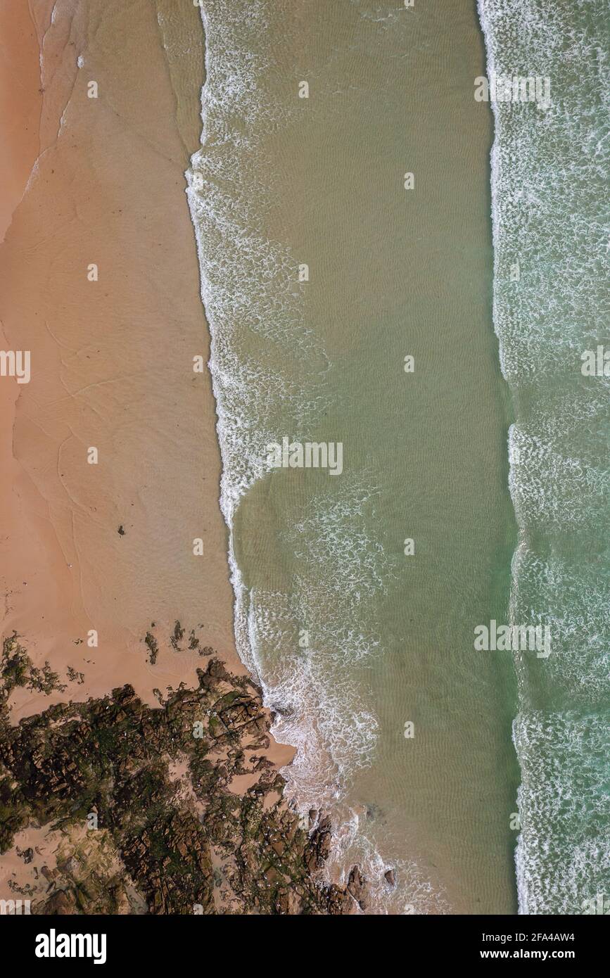 Abstrakte Drohne Luftaufnahme von oben auf einen wilden Strand mit Sand und Wellen Stockfoto