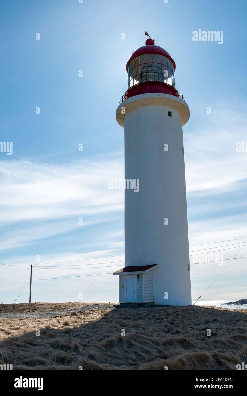 Ein runder oder zylinderartigen Leuchtturm aus weißem Beton und einem roten Lichtwächter-Wachturm. Das Gebäude steht auf einem Felsen. Stockfoto